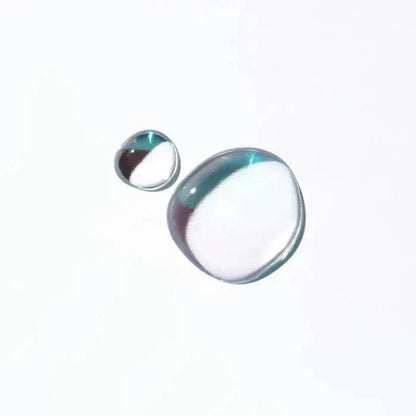 Two clear, spherical water droplets floating against a white background.