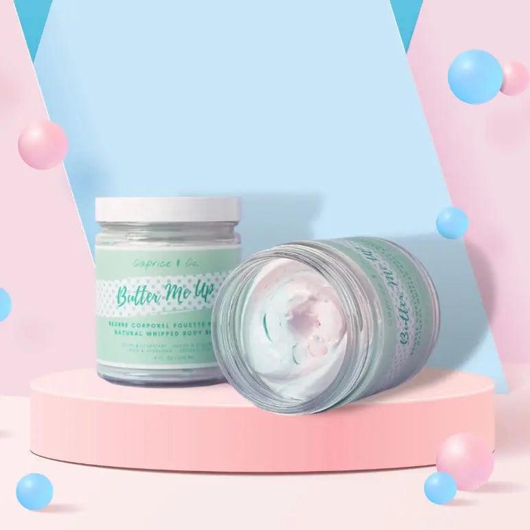 Butter Me Up Cotton Candy body butter jar on a pastel display, highlighting its whipped texture and moisturizing properties.
