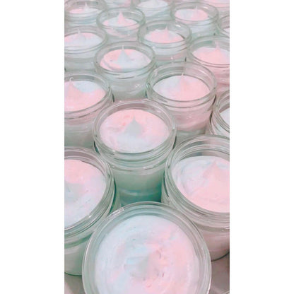 A collection of jars filled with air-whipped cotton candy body butter, showcasing soft pastel colors and creamy texture.