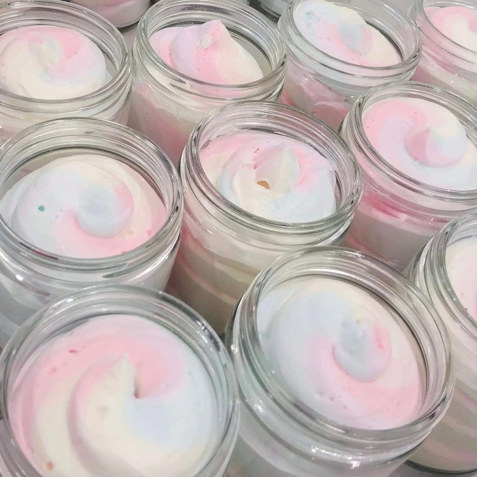 Close-up of jars filled with fluffy, pastel-colored whipped body butter resembling fruit loops scent.