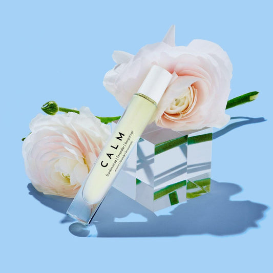 "Calm aromatherapy roller with floral background on a blue surface, perfect for relaxation and stress relief"