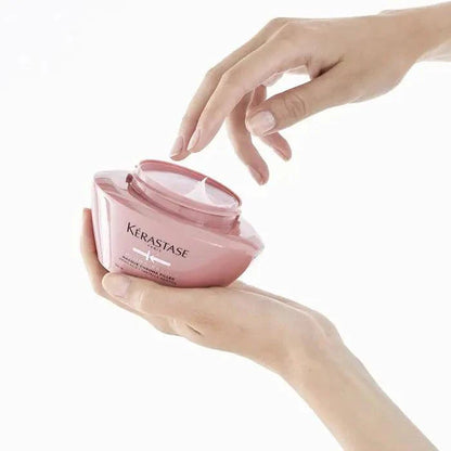Hands holding Kerastase hair product jar for enhancing hair care and smoothness