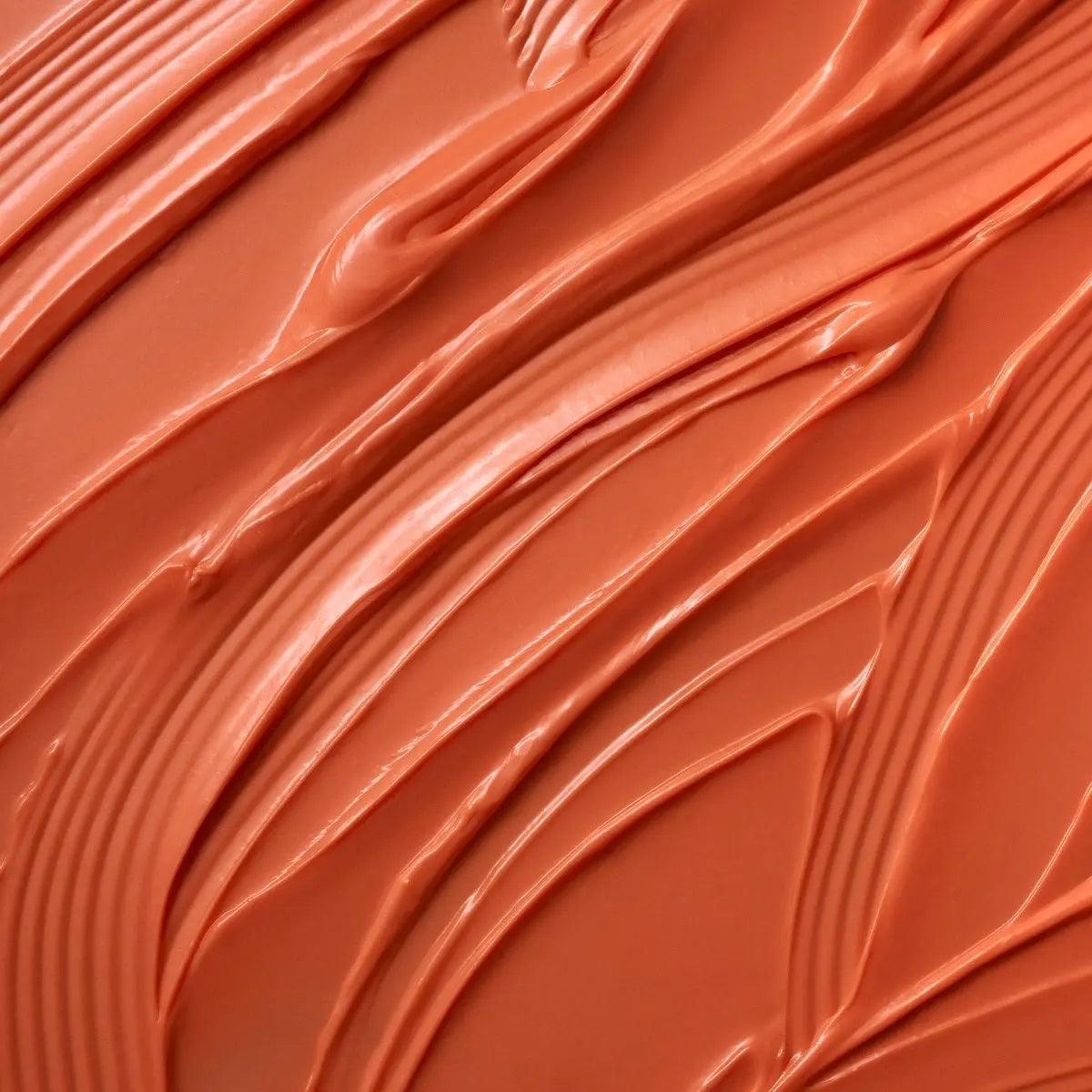 Close-up of Moroccanoil Color Depositing Mask in warm peach hue, showcasing its creamy texture.