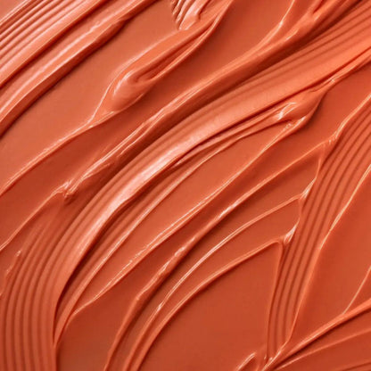 Close-up of Moroccanoil Color Depositing Mask in warm peach hue, showcasing its creamy texture.