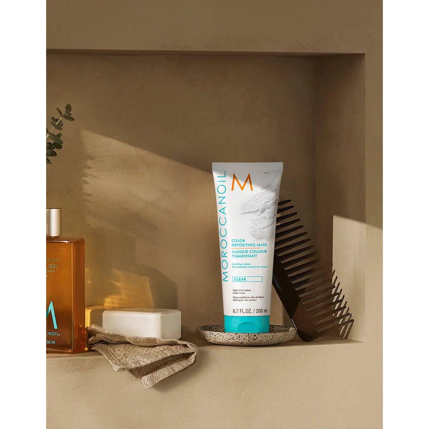 Moroccanoil Color Depositing Mask displayed on a shelf with hair care products, enhancing hair color and shine.