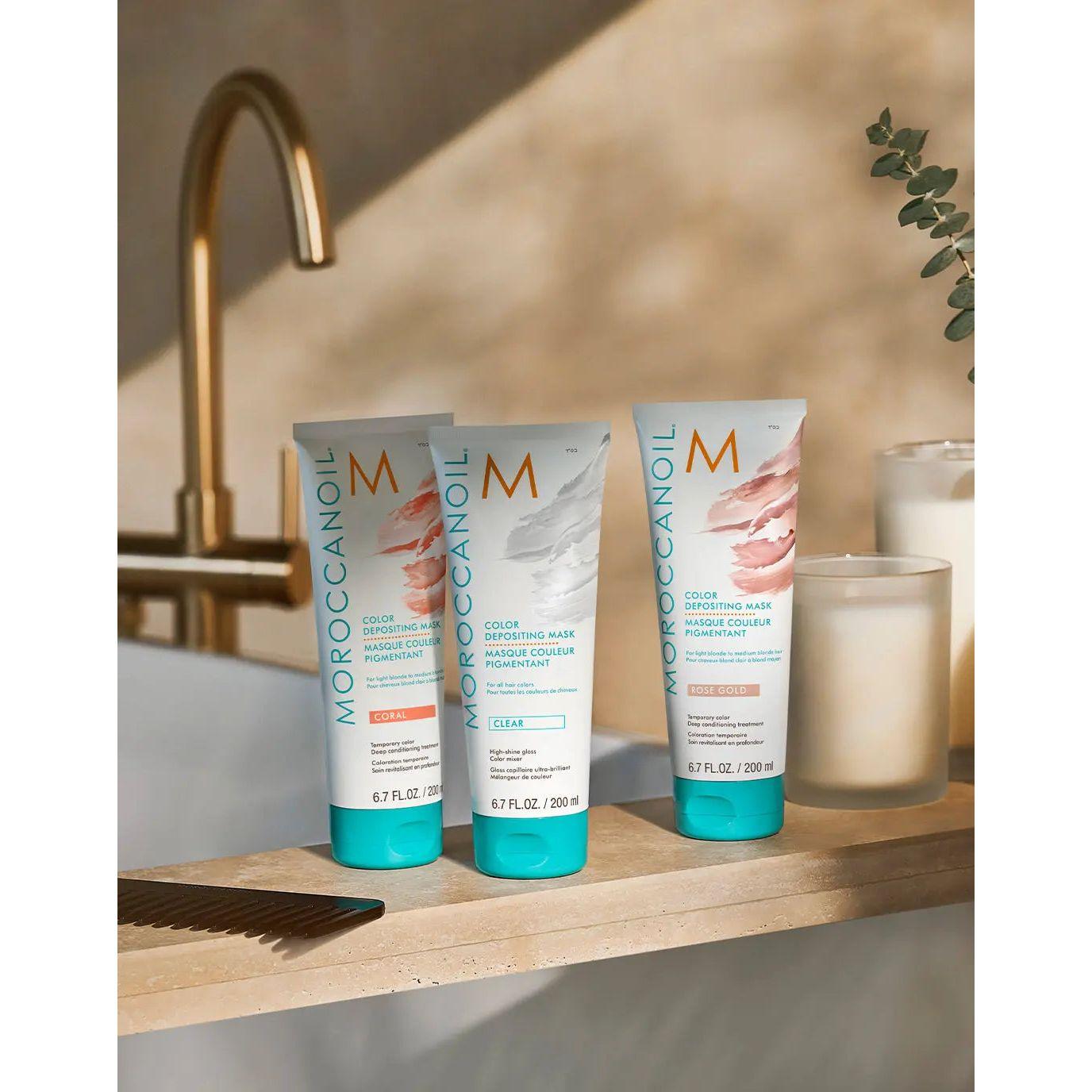 Moroccanoil Color Depositing Masks displayed on a countertop with candles and a comb for rejuvenating hair color.
