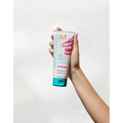 Moroccanoil Color Depositing Mask in hand, revitalizing hair color and enhancing shine.