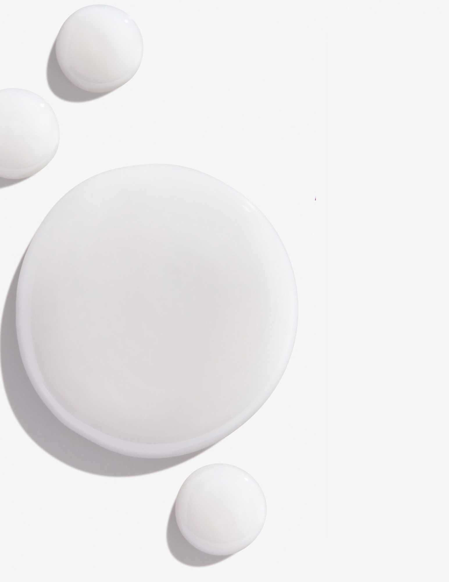 White drops of shampoo representing Redken Color Extend Magnetics Shampoo's creamy texture and formula.