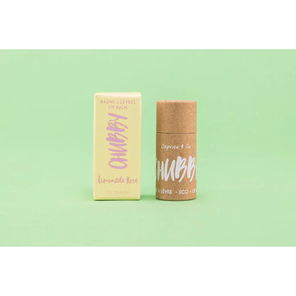 Compostable vegan lip balm with eco-friendly packaging on a green background, perfect for hydration and lip care.