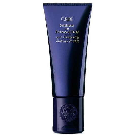 Oribe Conditioner for Brilliance & Shine in blue bottle with gold lettering, designed to enhance hair shine and smoothness.