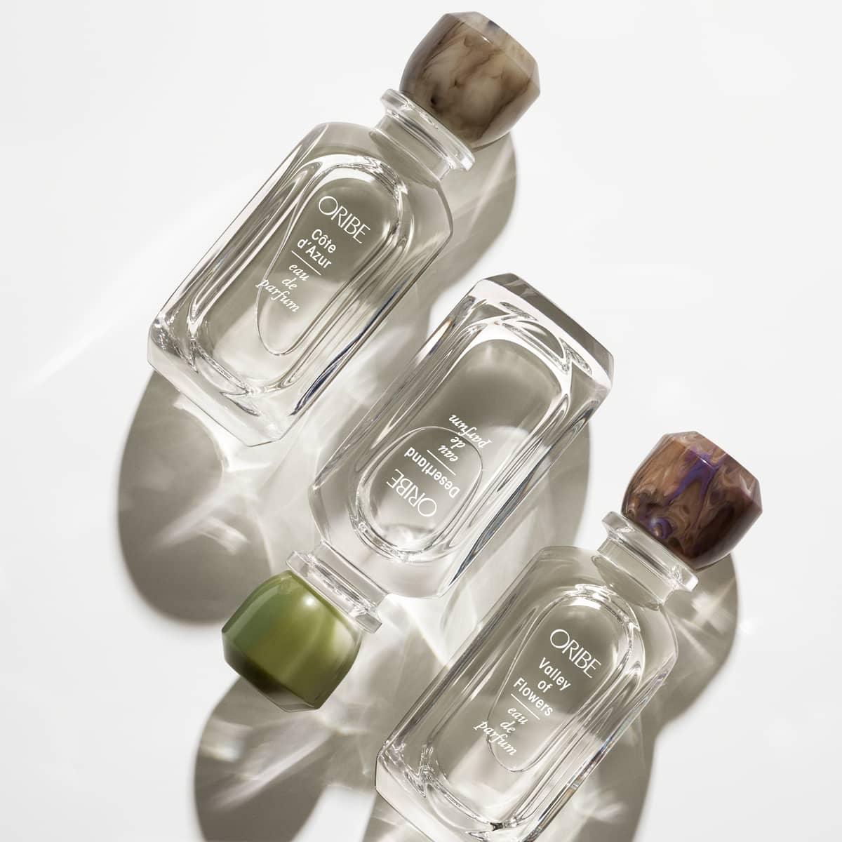Oribe Eau de Parfum Collection with elegant glass bottles and unique caps - luxury fragrances for men and women.