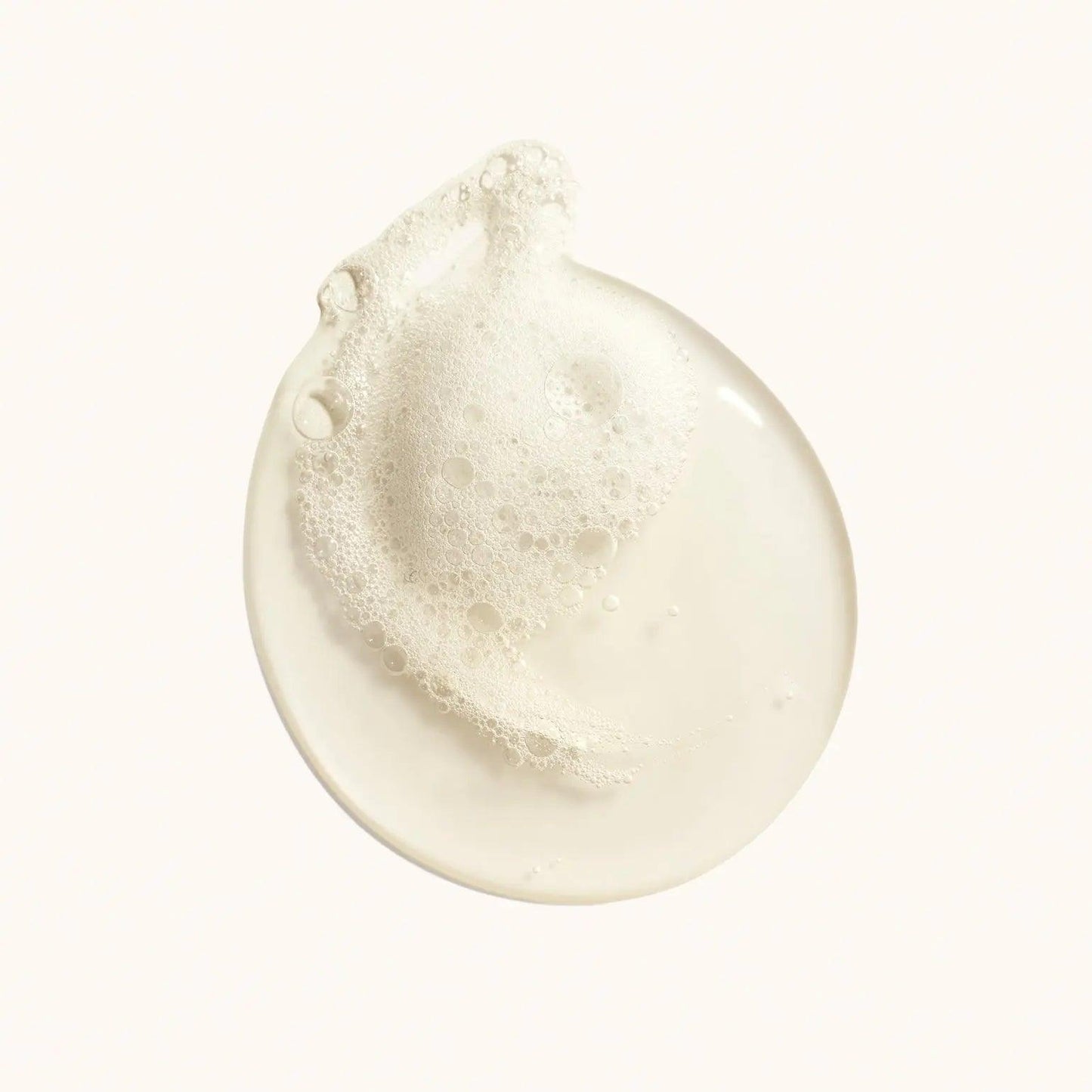 Pearlescent bubble lather of Desertland Replenishing Body Wash on a light background.