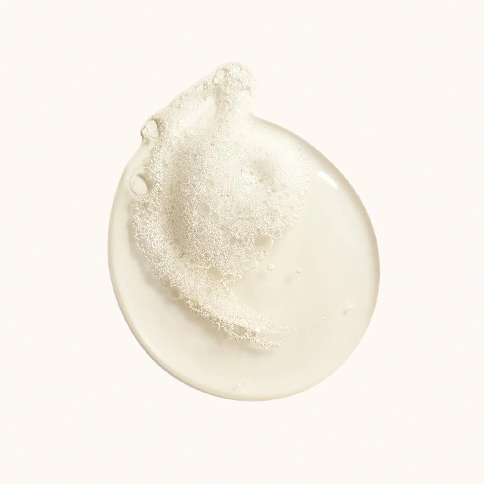 Pearlescent bubble lather of Desertland Replenishing Body Wash on a light background.