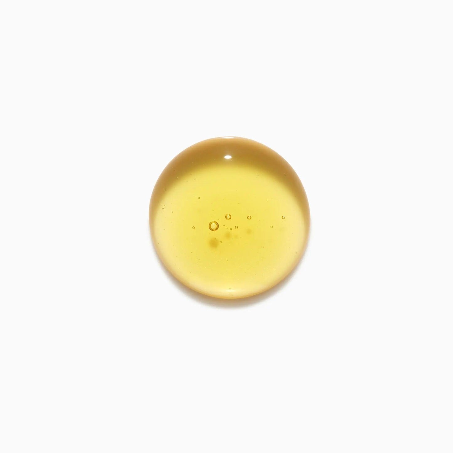 Clear drop of yellow essential oil for skincare on white background