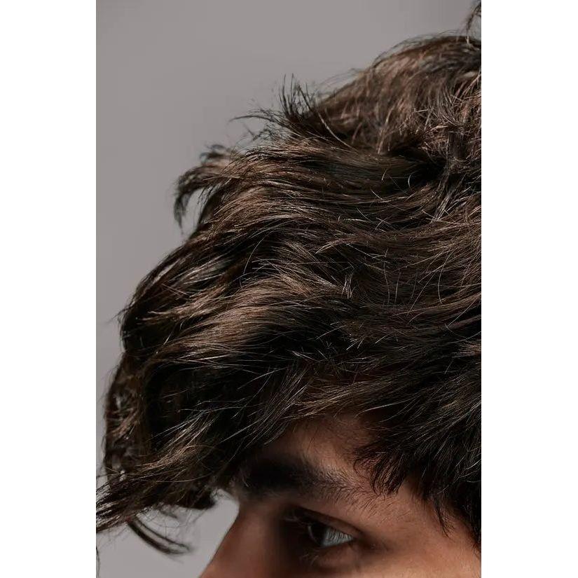 Close-up of thick, wavy dark hair styled elegantly on a young man's head