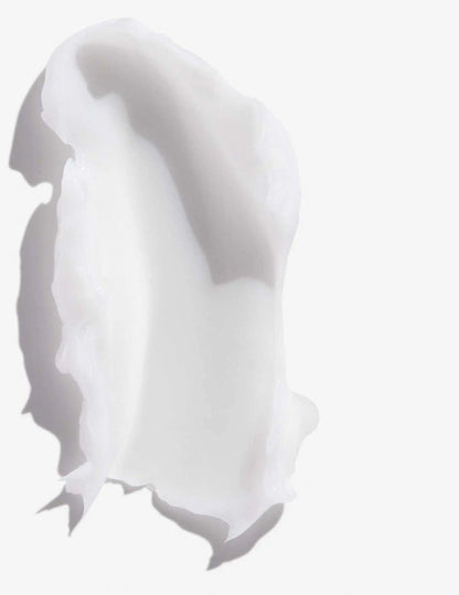 Creamy texture of Redken Frizz Dismiss Conditioner on a white background for frizz control and hair smoothness.