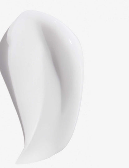 Smooth, white texture of Redken Frizz Dismiss Mask, designed for frizz-free, manageable hair.