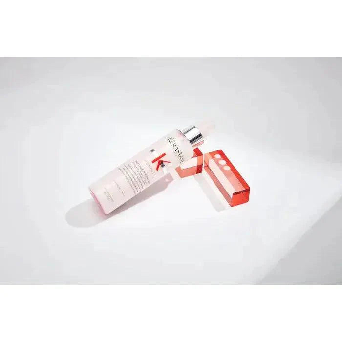 Anti-aging skincare serum bottle with red cap on white background.