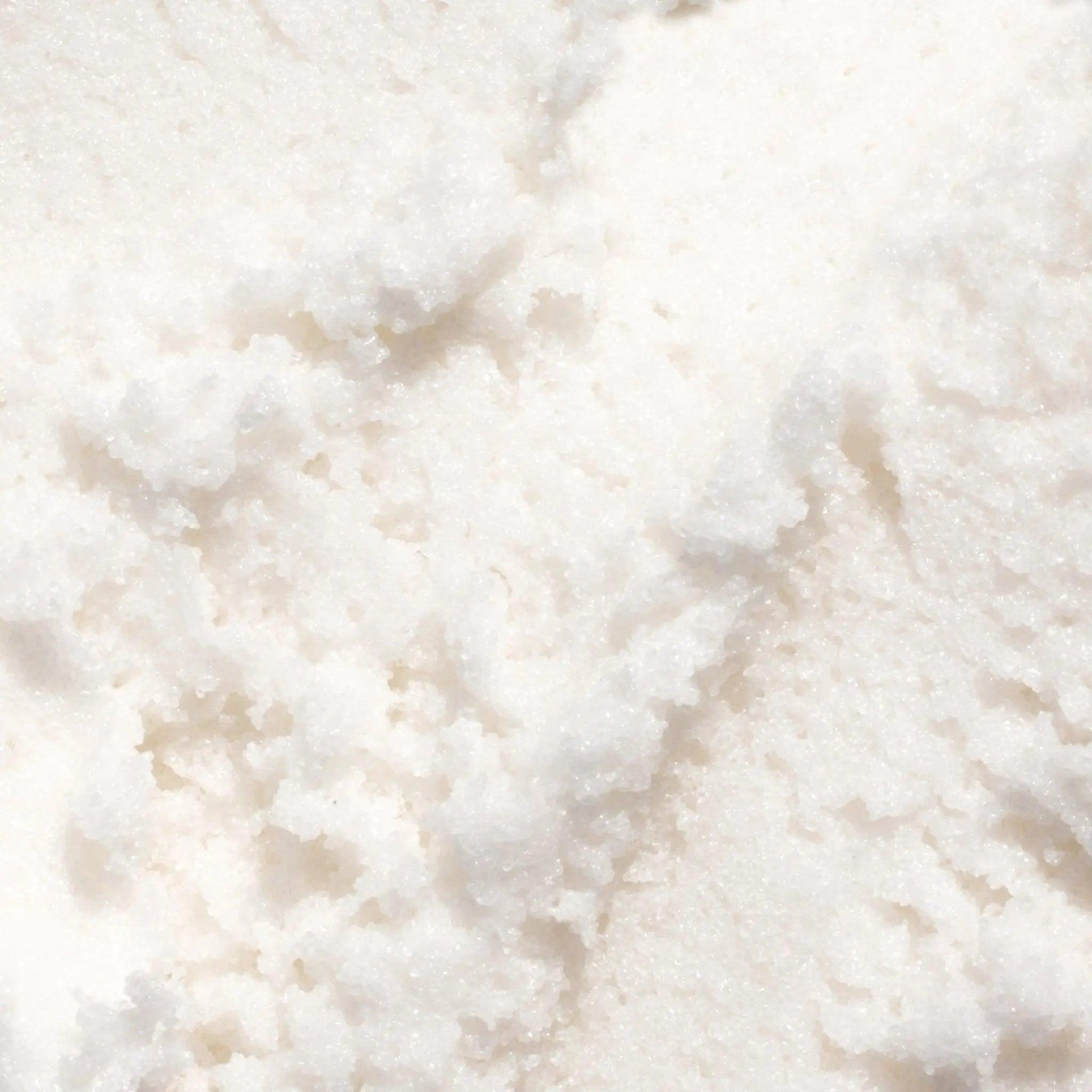 Gilded Woods Body Scrub texture featuring a fluffy, moisture-rich white formulation with pure cane sugar and coconut oil.