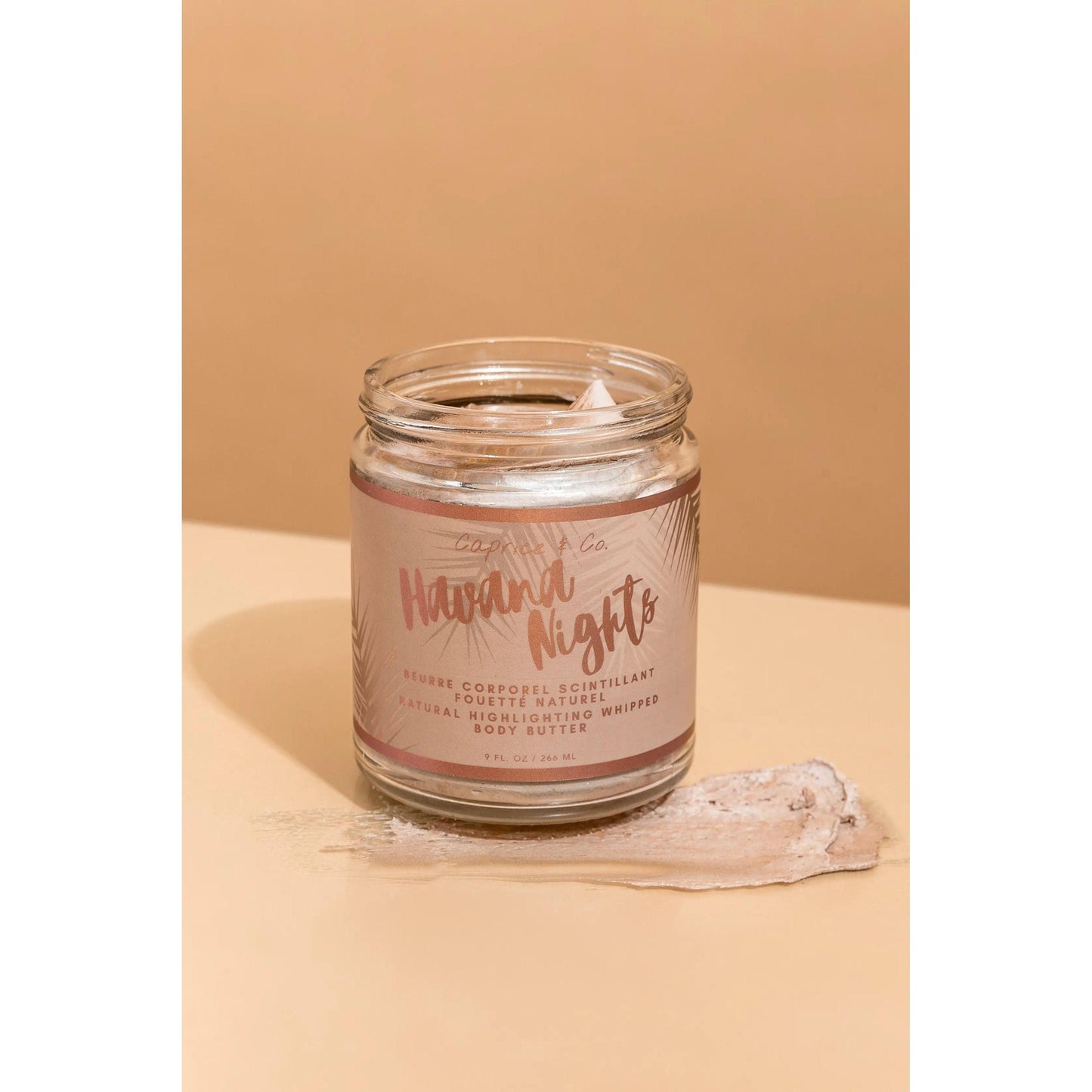 Havana Nights Bronze Body Butter jar displaying moisturizing formula with Ghanaian ingredients on a warm background.