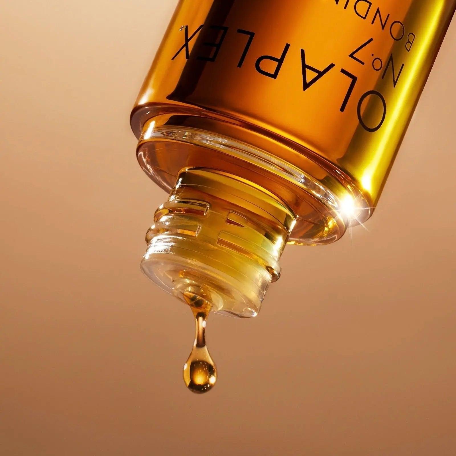 Close-up of Olaplex No.7 Styling Oil bottle, showcasing the golden oil dripping from the top for hair protection and shine.