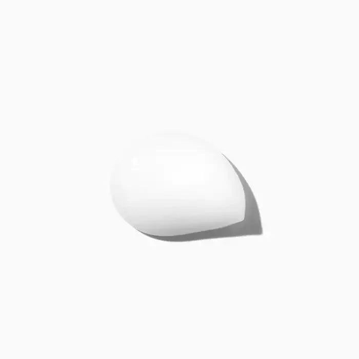 White minimalist sculptural object casting shadow on white background