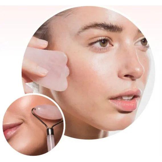 Woman using rose quartz gua sha and facial roller for skincare, enhancing complexion and reducing tension.