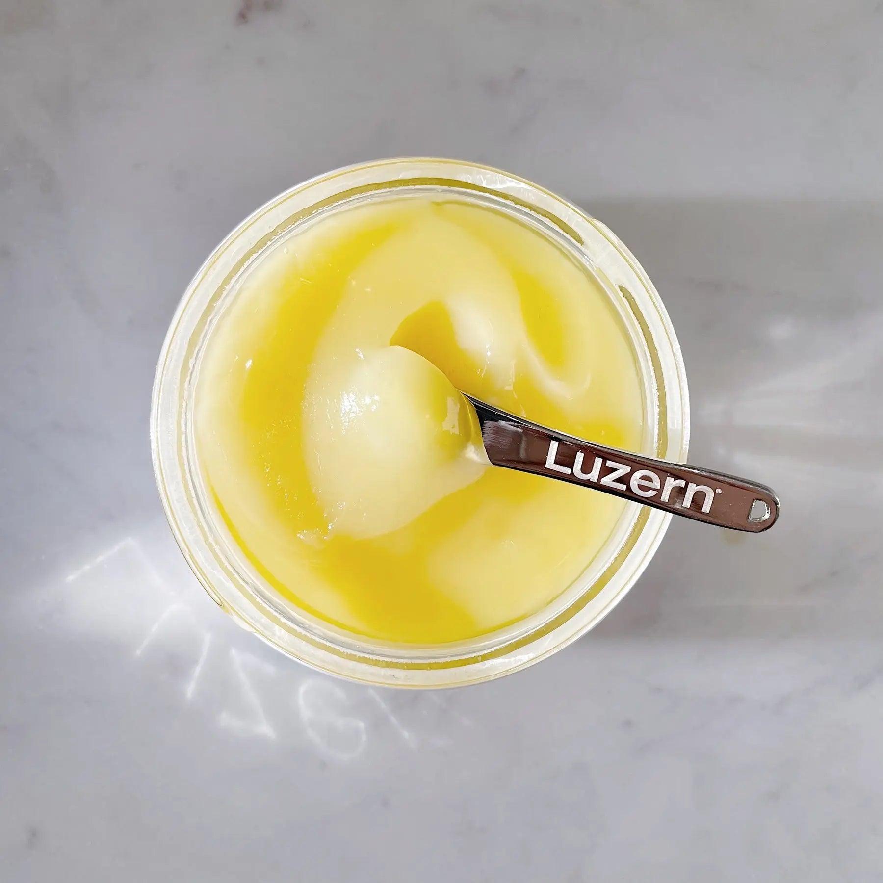 L'Essentials Emulsion 6 in a jar, showcasing a creamy, nutrient-rich texture with a spoon for application.