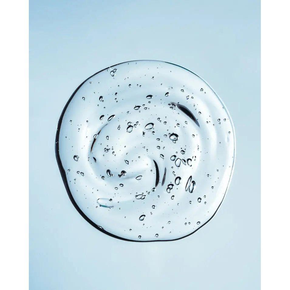 Smooth, clear hand sanitizer gel with bubbles on a light background, showcasing its non-sticky texture.