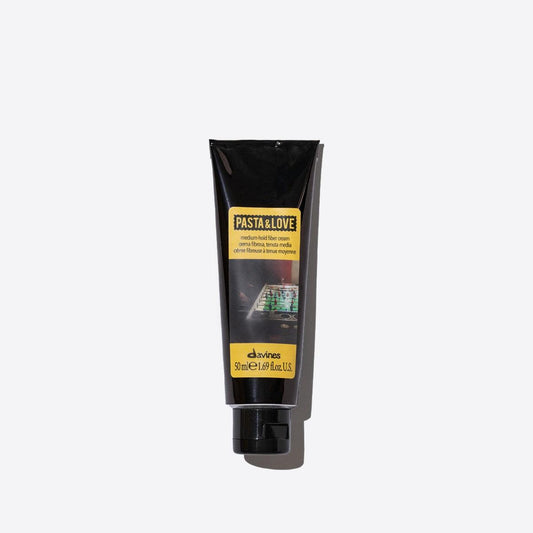 Medium hold fiber cream in a sleek black tube, designed for flexible styling and natural finish for all hair types.