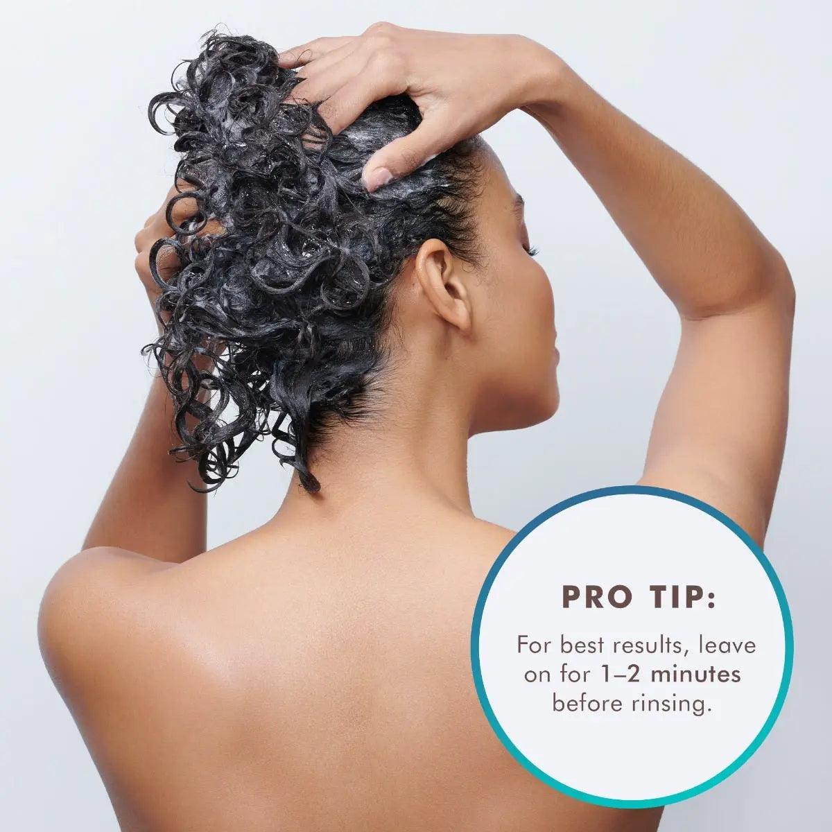 Woman applying Moisture Repair Conditioner, with a tip to leave in for 1-2 minutes before rinsing for best results.