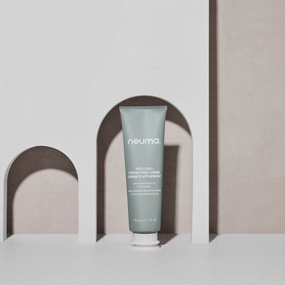 Neuma Neu Curl Perfecting Crème in a tube, enhancing curls with coconut hibiscus aroma for frizz-free waves.