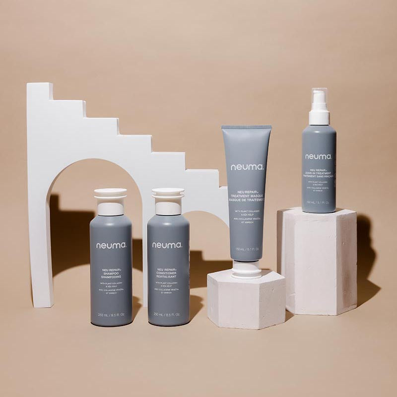 Neuma haircare products including repair treatment masque on display with modern geometric backdrop for hair health restoration.