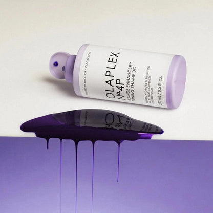 Olaplex Nº.4P Blonde Enhancer Toning Shampoo bottle with purple shampoo spilling on a surface, ideal for vibrant blonde hair.