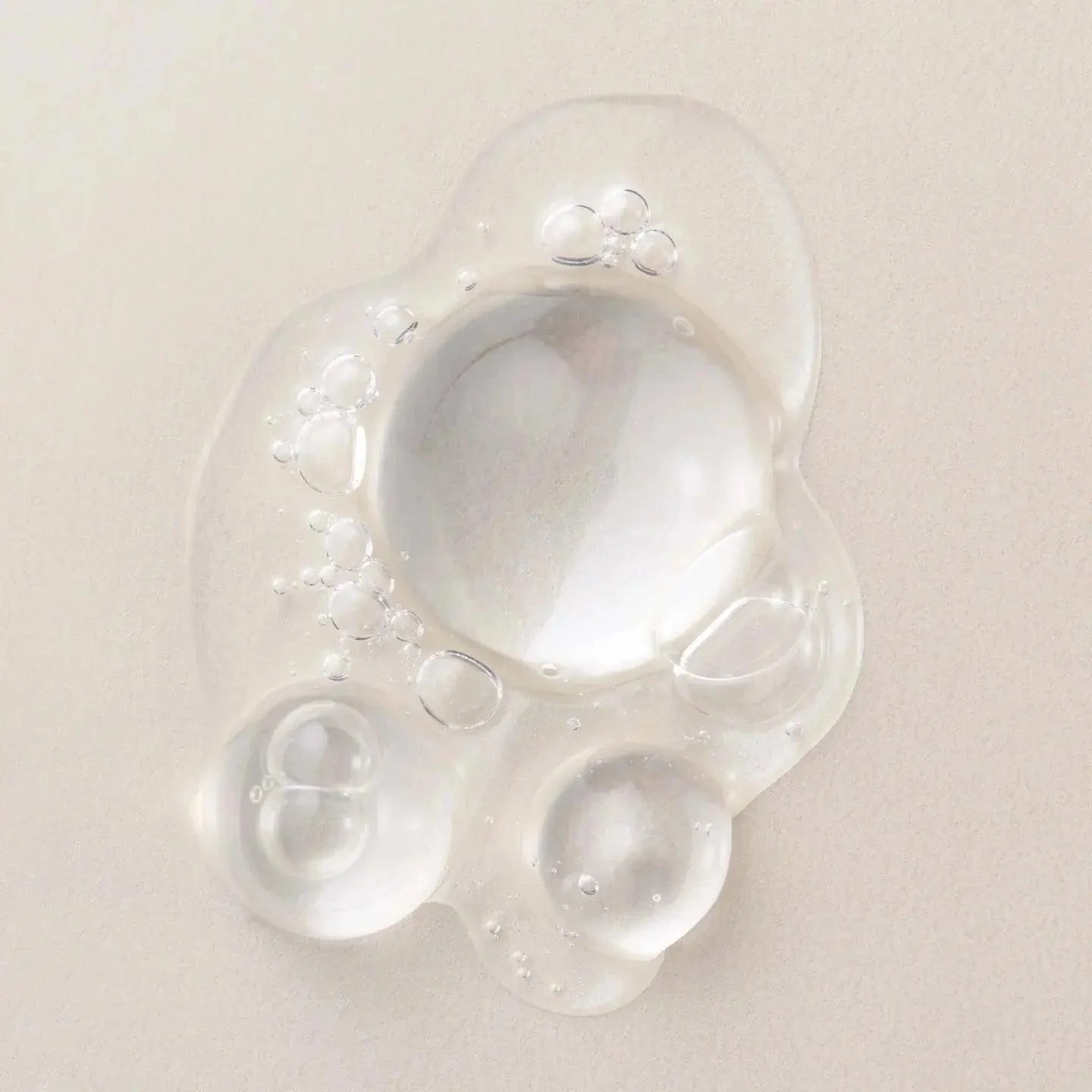 Clear, lightweight hair serum drops showcasing nourishing bubbles for hair protection and shine.