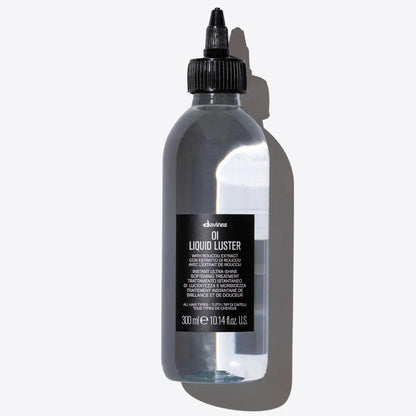 Oi Liquid Luster by Davines in a clear bottle, a weightless treatment for shiny, silky hair with a glass-like finish.