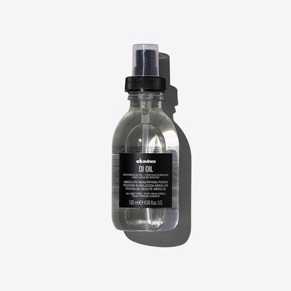 "Davines OI Oil, 135ml bottle, hair beautifying potion, with roucou oil, transparent liquid, black spray cap, product shot on white background"