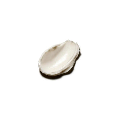 Smooth, creamy texture of Original Body Butter lotion on a spoon, showcasing its rich, moisturizing formula.