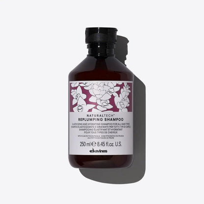 Replumping Shampoo bottle with creamy texture, 250 ml, enhances elasticity and hydration for healthy hair.