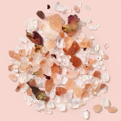 Himalayan pink salt with rose petals on a pink background