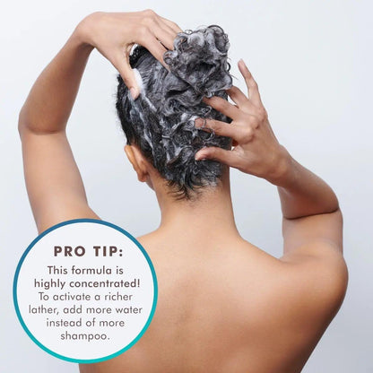 woman applying concentrated smoothing shampoo to hair with a pro tip about adding water for lather enhancement.
