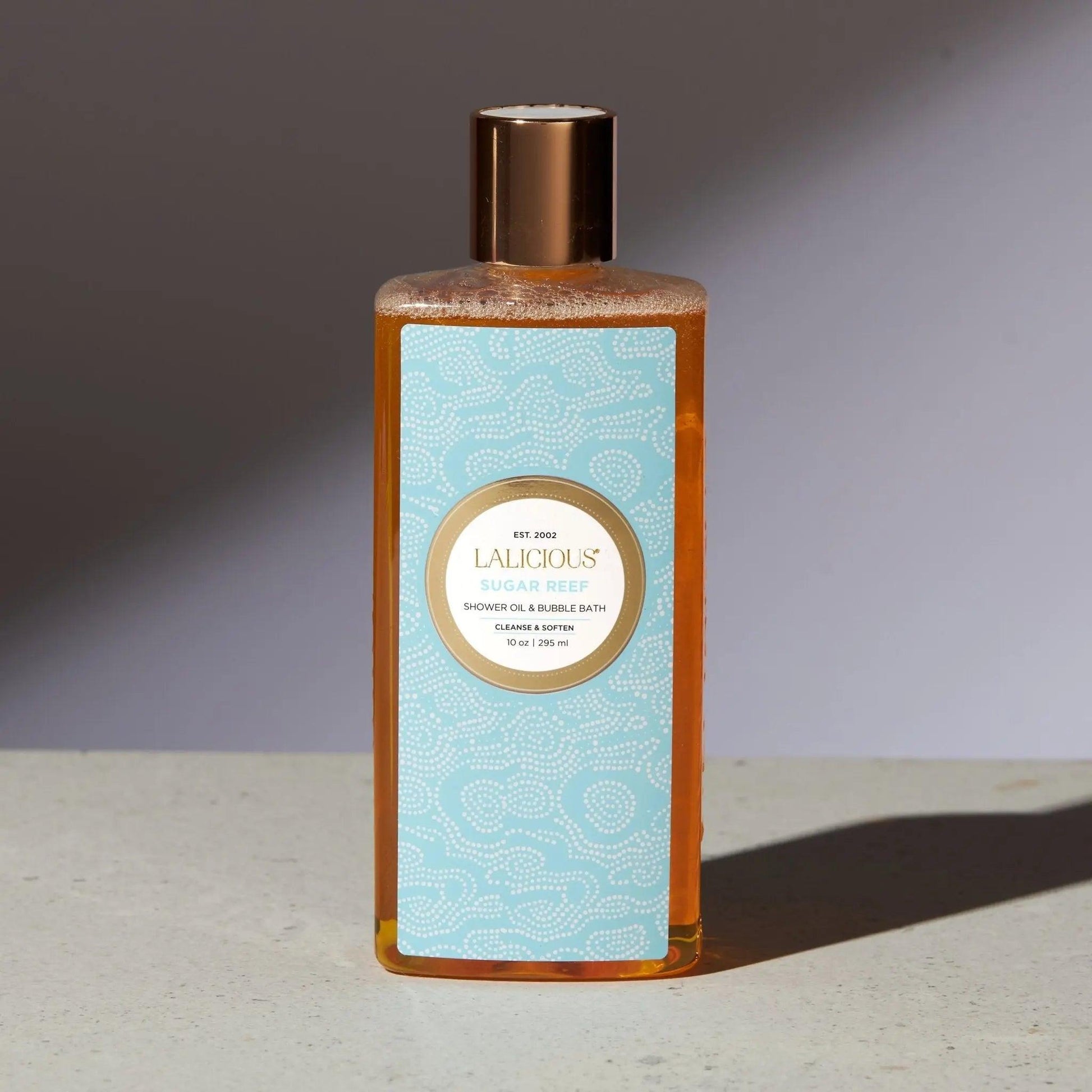 Sugar Reef Shower Oil & Bubble Bath in elegant bottle, showcasing luxurious moisturizing formula for skin cleansing.