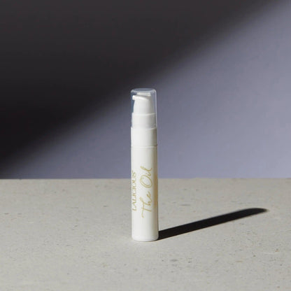 Luxurious The Oil bottle on a textured surface, showcasing its elegant packaging and modern design.