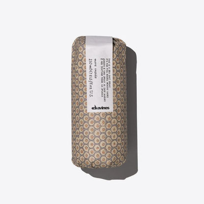 Davines hair product in patterned cylindrical packaging on a white background