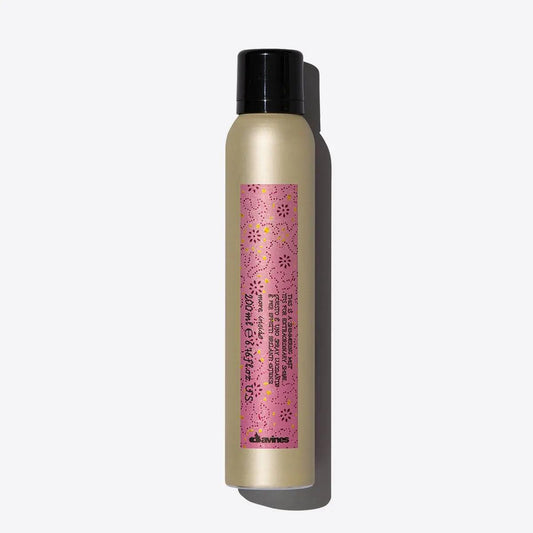 Davines dry texturizer for hair styling in a pink and gold bottle with black cap.