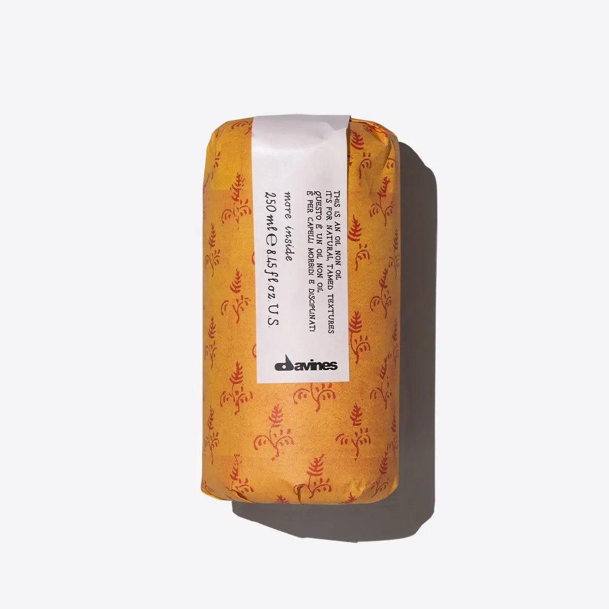 Davines hair care product in yellow patterned packaging with white labeling on neutral background