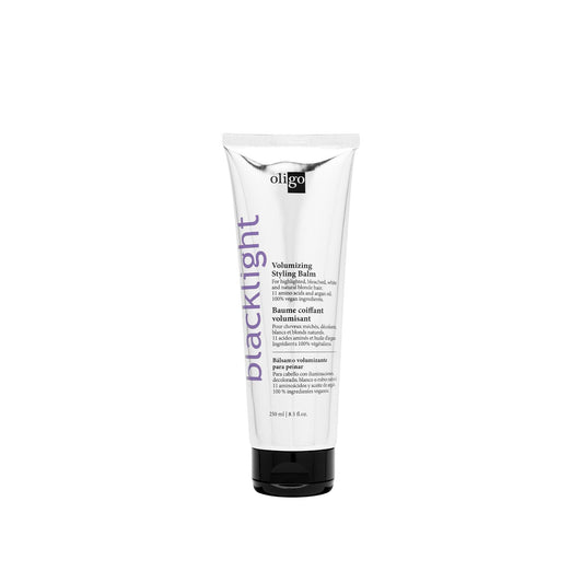 Blacklight Volumizing Styling Balm tube for frizz control, flexible hold, and color protection in hair care.