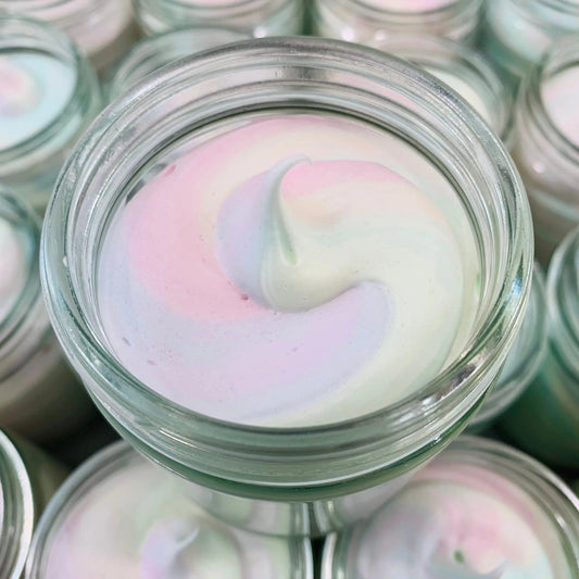 Close-up of natural whipped soap in a jar, featuring a fluffy swirl of pastel colors. Ideal for moisturizing and sensitive skin.
